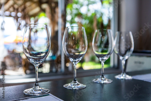 Side by side various sizes of wine empty glasses on a restaurant table selective focus view, goblets for drink and taste wines, tasting room stemware