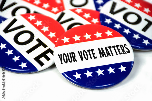 collection of election campaign vote pins on white