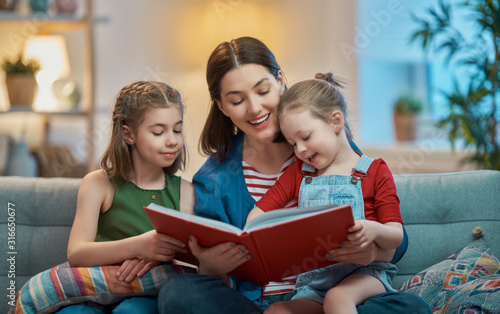 mother reading a book to daughters