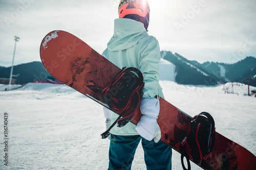 One young woman snowboarding in winter mountains