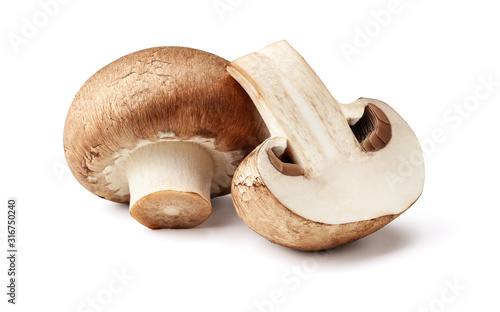 Two fresh mushrooms champignons, one whole and the other cut in half isolated on white background with clipping path