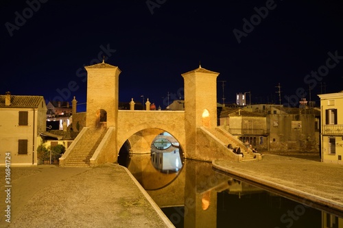paesaggio notturno del complesso architettonico Trepponti del 1638, il ponte più famoso e il monumento più rappresentativo della città di Comacchio in provincia di Ferrara, Italia