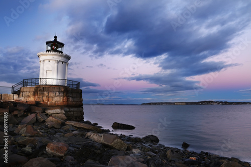 Lighthouse on the pier on the bay. evening photo. Dynasty Exposition. Sunset sky and calm water. USA. Maine Portland.