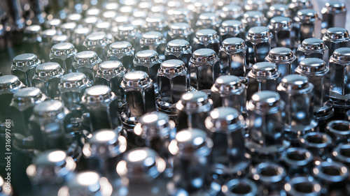 metal wheel nuts laid out on the surface, blurred image, car maintenance, replacing wheels