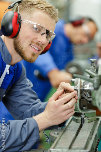 portrait of engineer using machinery and wearing goggles