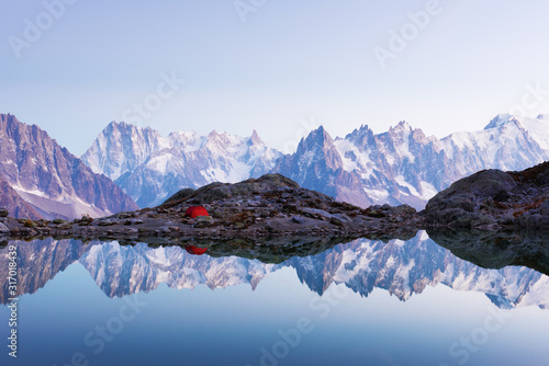 Red tent on Lac Blanc lake coast in France Alps. Monte Bianco mountains range on background. Landscape photography, Chamonix.