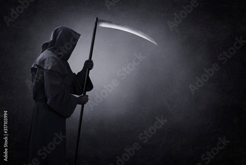 Grim reaper with scythe in the dark