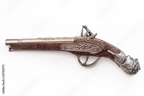 Firearms dating to the american revolution and antique collectables concept with ornate old fashioned dueling flintlock pistol isolated on white background with clipping path cutout