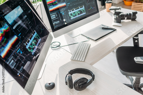 selective focus of computer monitors near headphones on table