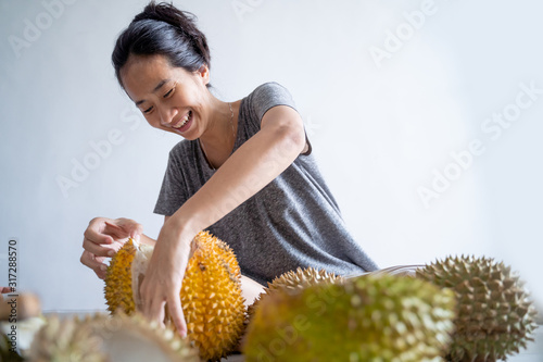 beautiful asian woman eating durian fruit at home