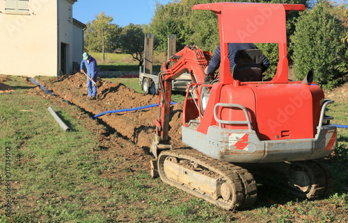 Pose des tuyaux dans la tranchée de raccordement d'une maison.