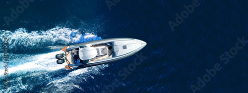 Aerial drone top down ultra wide photo of inflatable speed boat cruising in high speed in deep blue Aegean sea