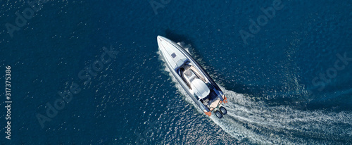 Aerial drone top down ultra wide photo of inflatable speed boat cruising in high speed in deep blue Aegean sea