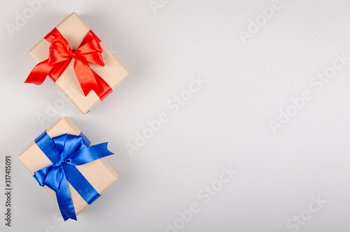 Gift box on gray background composition, present with ribbon and bow.