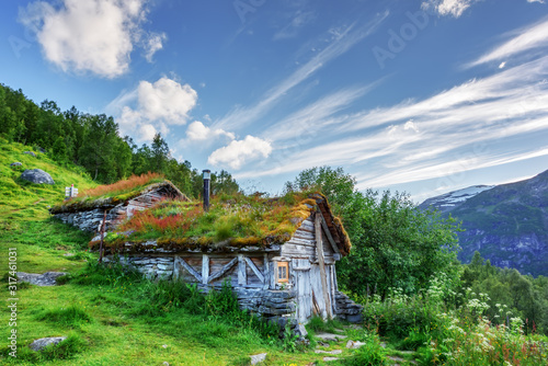 Typical norwegian old wooden houses with grass roofs near Sunnylvsfjorden fjord and famous Seven Sisters waterfalls, western Norway. Landscape photography