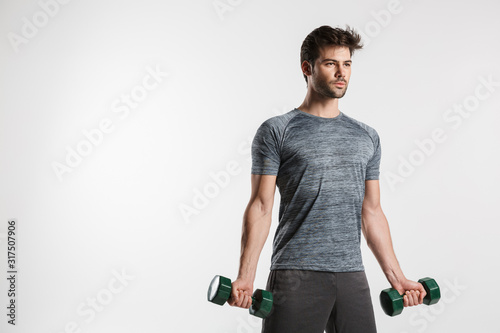 Image of handsome athletic man doing exercise with dumbbells