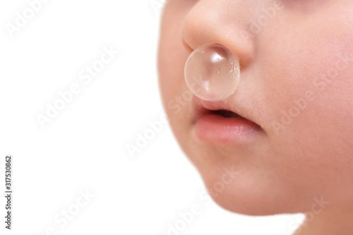 Baby girl and big bubble of snot from nose close up.