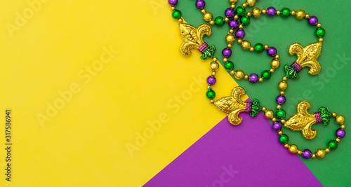 Mardi gras carnival decoration beads yellow green purple background
