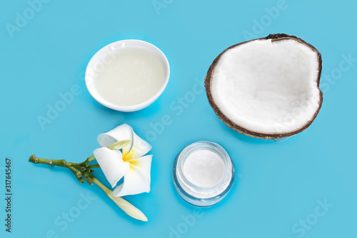 Set of coconut for beauty, health of hair, face, skin. Coconut cut in half, coconut oil, cream, flower. Beauty healthcare concept. Coconut cosmetic fresh organic natural products. Blue background