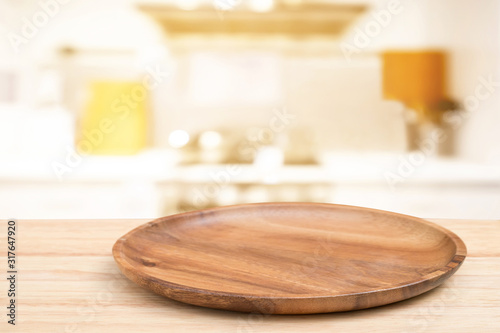 Empty wooden tray on perspective wooden table on top over blur flower background. Can be used mock up for montage products display or design layout.