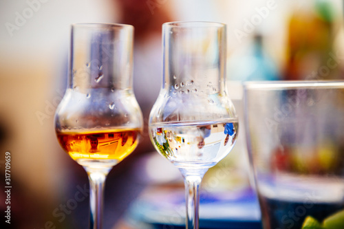 Two grappa glasses with brown and light grappa at a garden party in summer