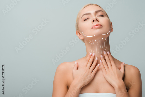 beautiful woman touching neck with lifting marks isolated on grey