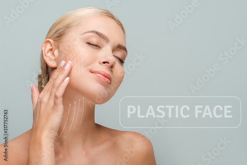 smiling woman touching face with facelift marks isolated on grey with plastic face illustration