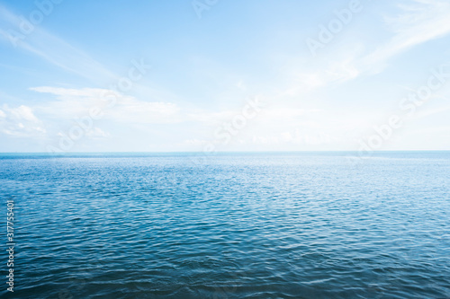 Blue sea with waves and sky with clouds.