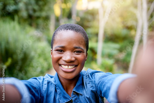 Young African American woman smiling and taking selfies outdoors