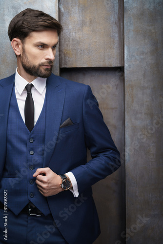indoor photo of young handsome stylish businessman wearing suit
