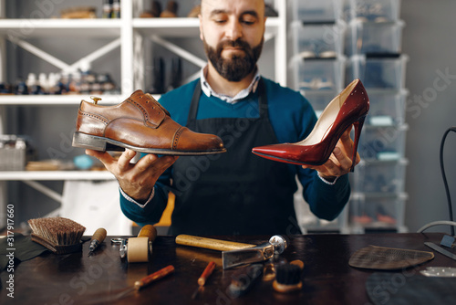 Bootmaker shows repaired shoes, footwear repair