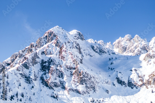 The snowy mountains, the woods and the mountain pastures during a fantastic winter day, near the town of Borno, Italy - December 2019.