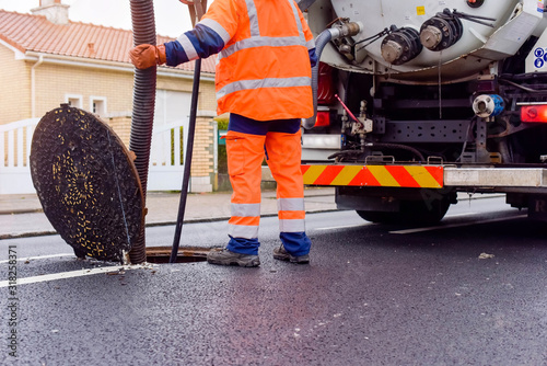 workers cleaning and maintaining the sewers on the roads