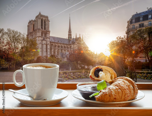 Coffee with croissants against cathedral Notre Dame in Paris, France