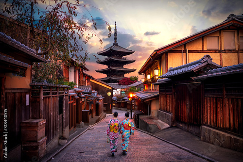 Two geishas wearing traditional japanese kimono among at Yasaka Pagoda and Sannen Zaka Street in Kyoto, Japan.