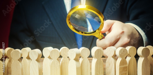Businessman is studying a crowd of people with a magnifying glass. Hr search candidates for work, staff recruiting. Society, demographic. Market and customers research. Citizens electorate. Sociology
