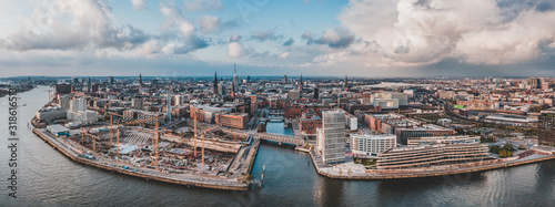 Aerial drone panoramic view of port of Hamburg from above before sunset with dramatic stormy clouds over historical city center