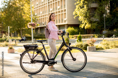 Young woman with modern city electric e-bike clean sustainable urban transportation