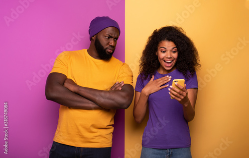 Girl receive a lot of hearths on social and boy is jealous about it. Yellow and violet background