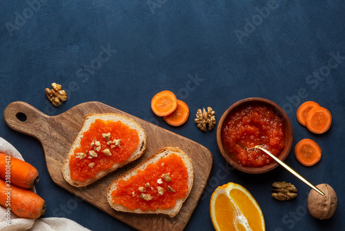 Sandwiches with carrot jam on a cutting board on a blue background