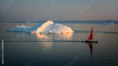 Greenland Ilulissat glaciers at ocean with res sailing boat