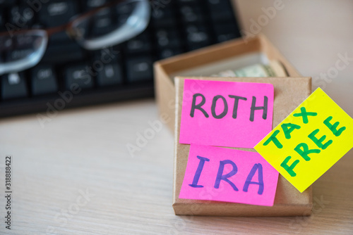 401k ira roth on pieces of colorful paper dollars on table. Pension concept. Retirement plans.