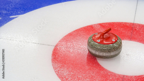 Curling winter, olympic sport.Curling stone and Ice curling sheet with red and blue circle and visible pebbles 
