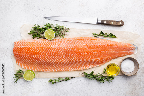 Fresh raw salmon or trout sea fish fillet with spices and herbs on white background, top view