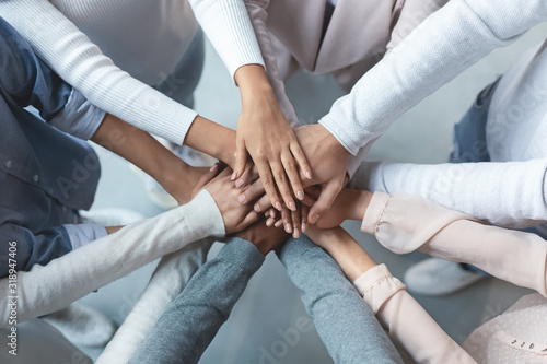 Multiracial business team putting hands on top of each other