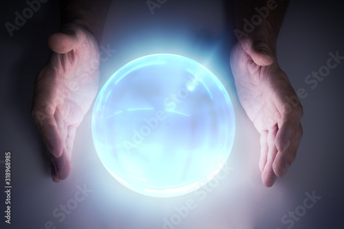 Magician or fortune teller is predicting future with crystal sphere.