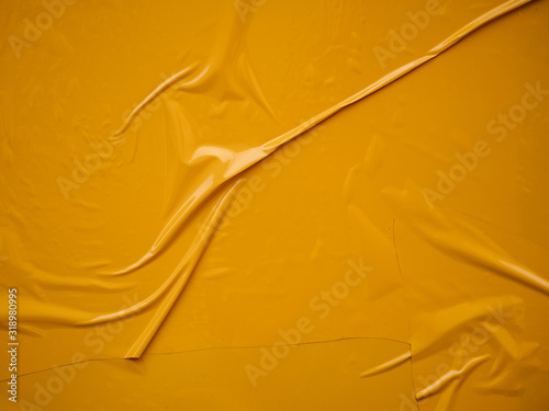 Yellow vinyl film overlapped pieces. Background from a film with a wavy texture glued to the surface