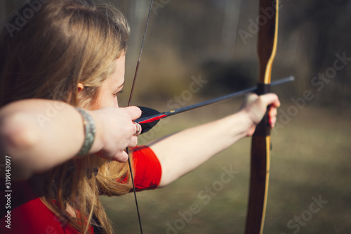 Girls dressed as medieval teaching archery at the field