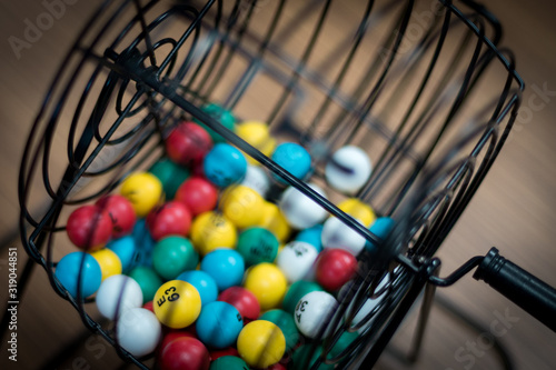 A bingo ball cage with colorful balls inside. 