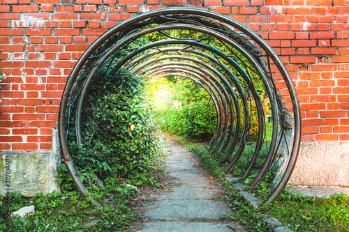 Abstract symbolic portal or passage in brick wall made of metal circular bars